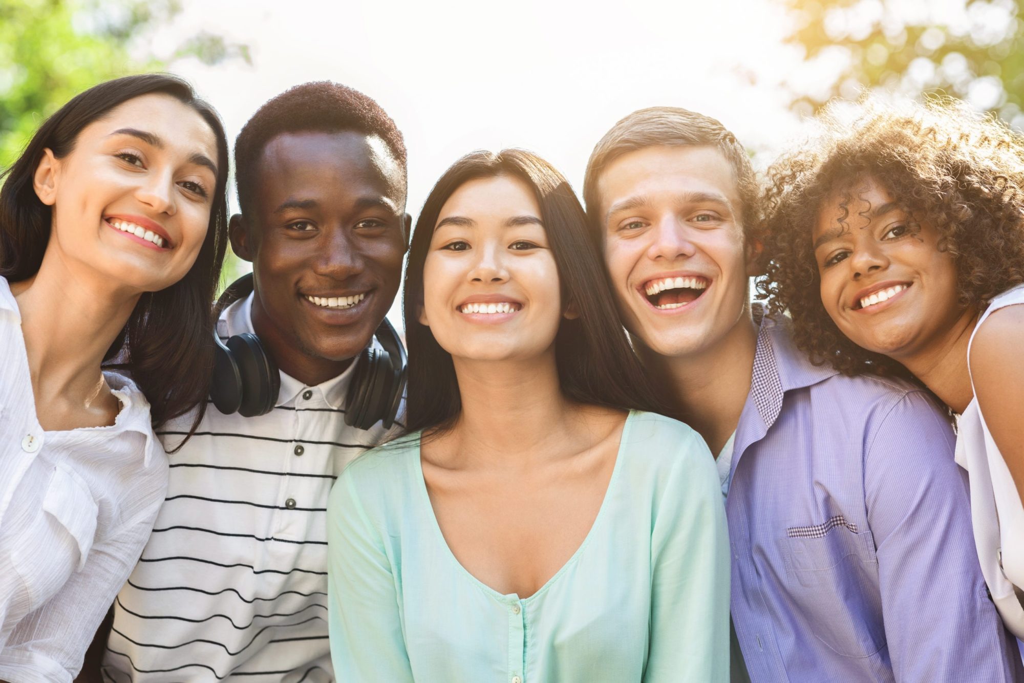 Portrait of cheerful interracial teen friends posing at camera outdoors Fairfield Orthodontics